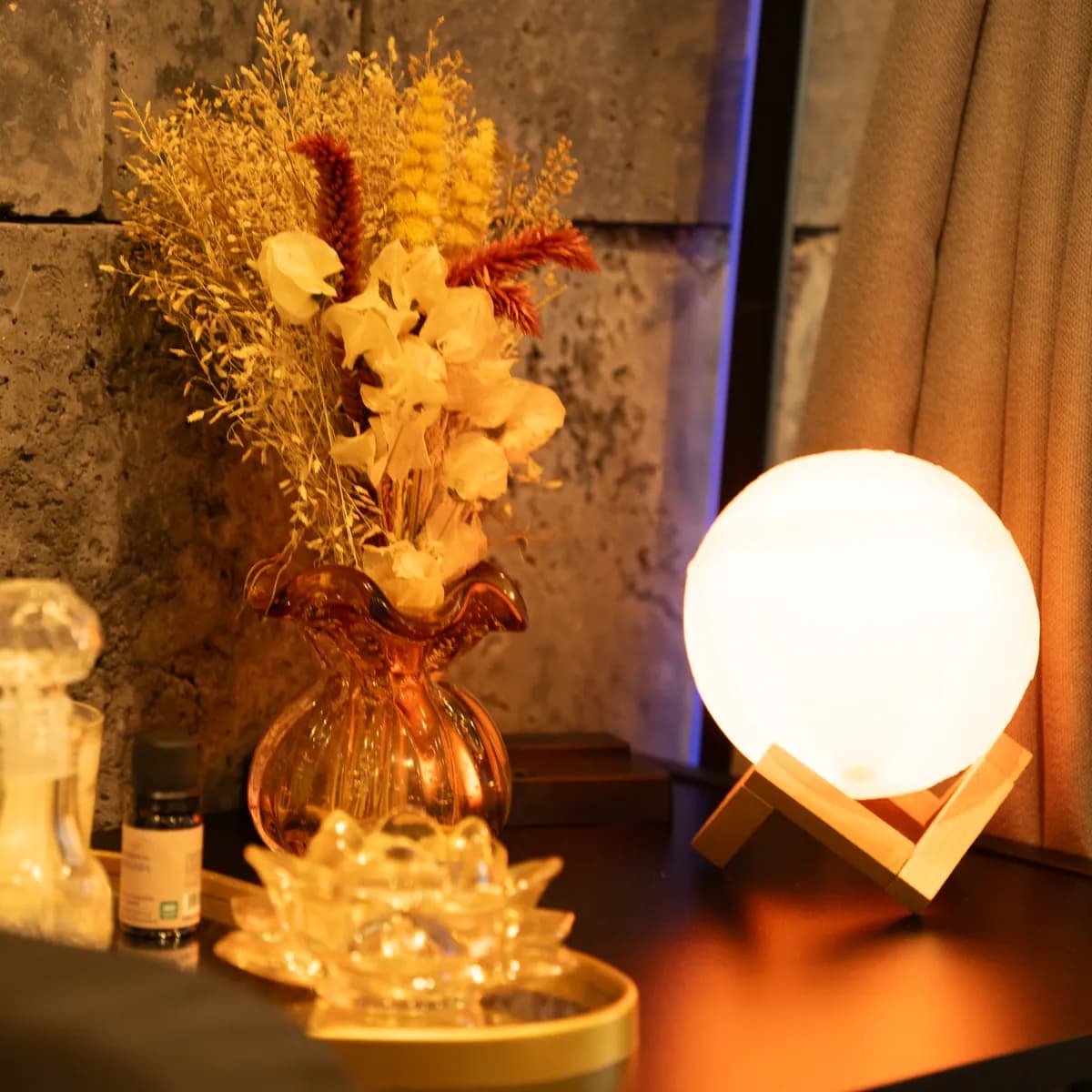 Arranjo de flores secas e luminária ao lado da maca