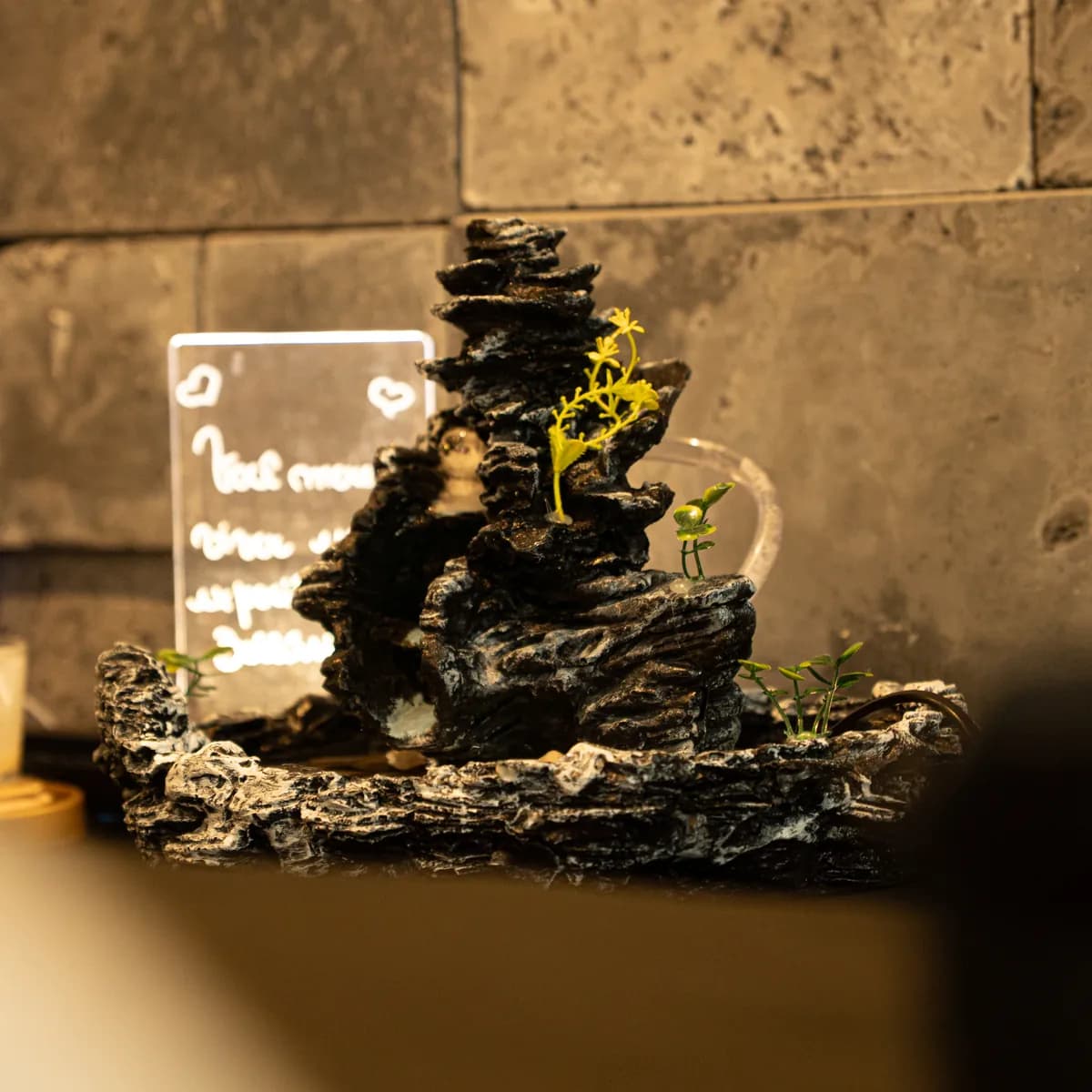 Fonte de água decorativa sobre a mesa lateral da sala de massagem