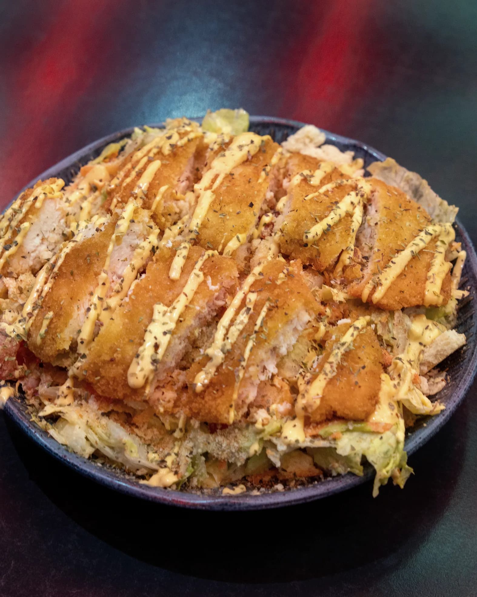 Bowl de frango empanado com salada servido no bistrô do clube