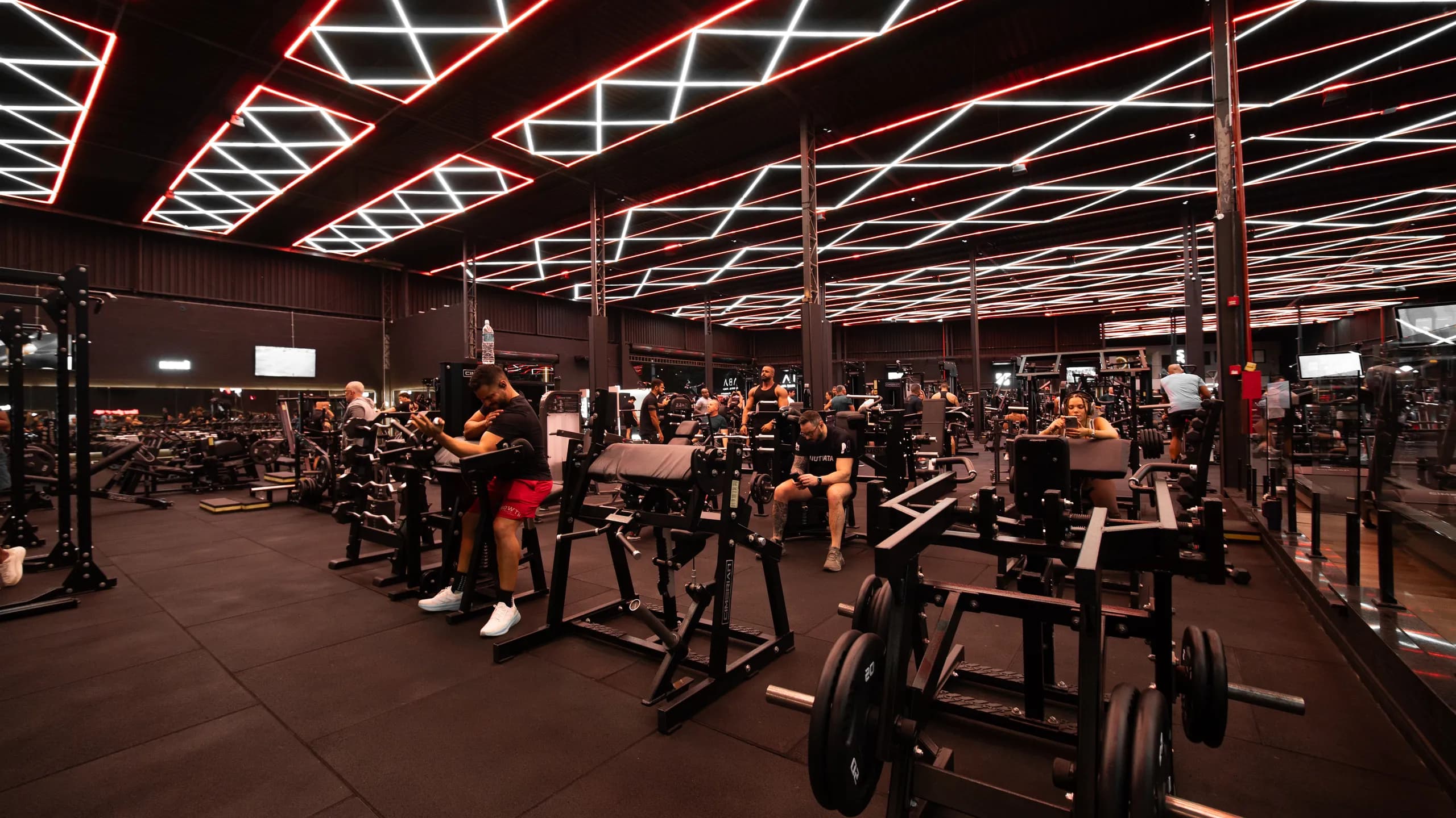 Salão de treino da Iron Zone com sócios usando as estações