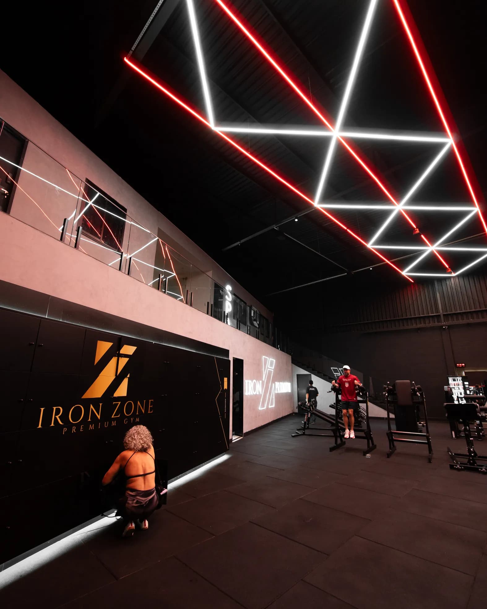 Mezanino do spa acima do salão, ao lado do letreiro dourado IRON ZONE PREMIUM GYM