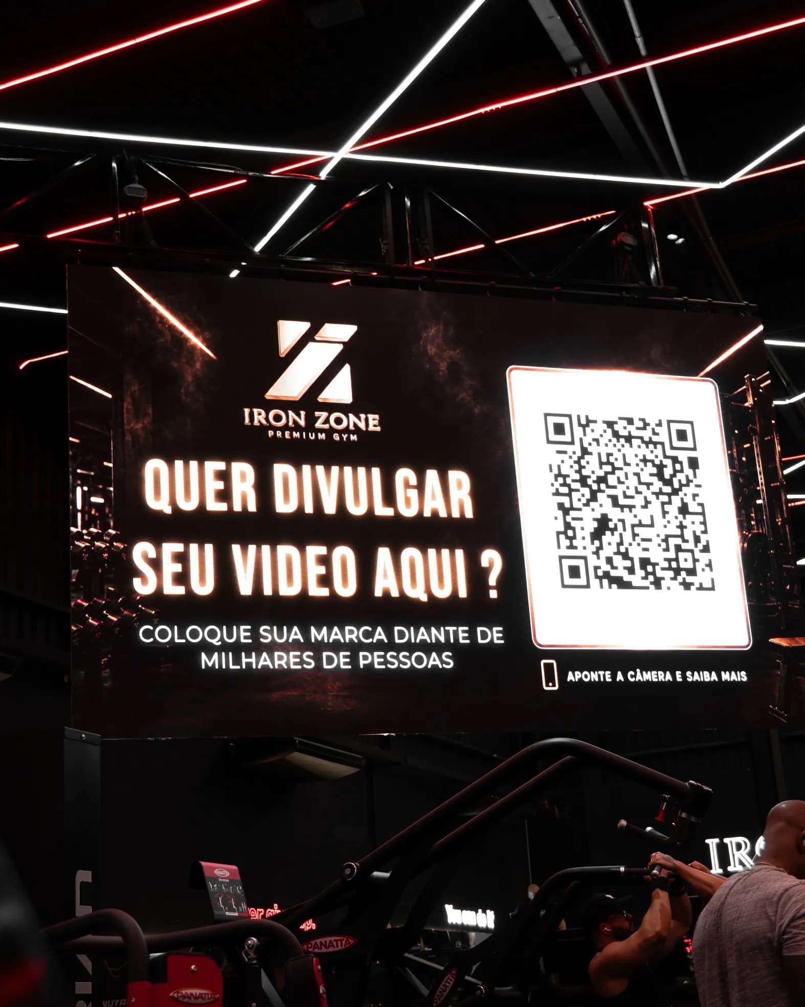Telão do salão em enquadramento vertical, exibindo o convite para anunciantes
